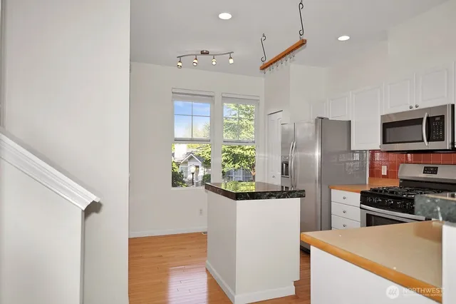 a kitchen with stainless steel appliances a refrigerator a stove a microwave and cabinets