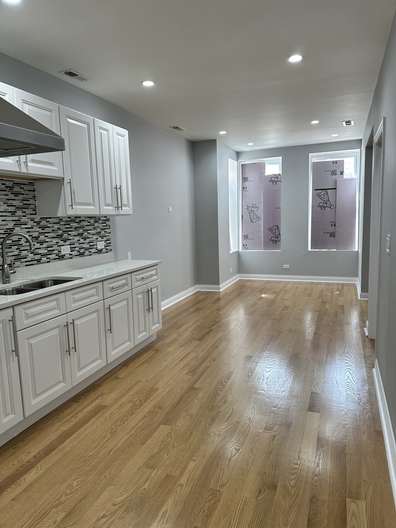 2002 West 21st Place, Unit GDN Chicago, IL 60608 - Photo 3 of 9 a view of an empty room with window and wooden floor