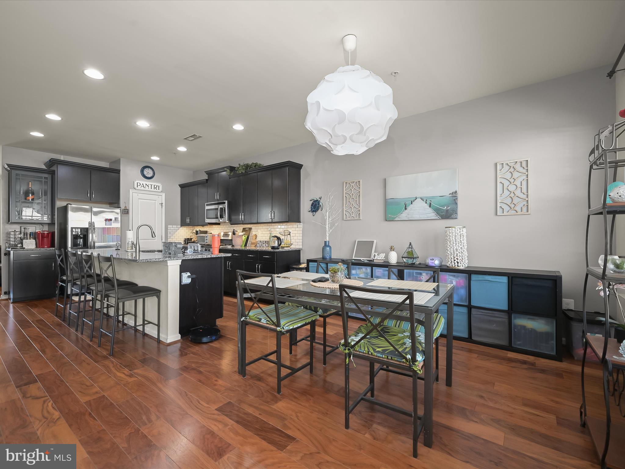 1117 Red Hawk Way Severn, MD 21144 - Photo 13 of 39 a view of a dining room and livingroom with furniture wooden floor a rug a painting and a chandelier