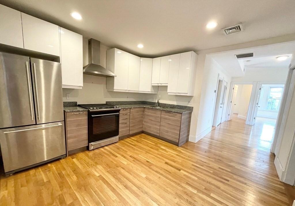 92 L Street, Unit 2 Boston, MA 02127 - Photo 2 of 15 a kitchen with stainless steel appliances granite countertop a refrigerator a sink dishwasher a stove and a refrigerator