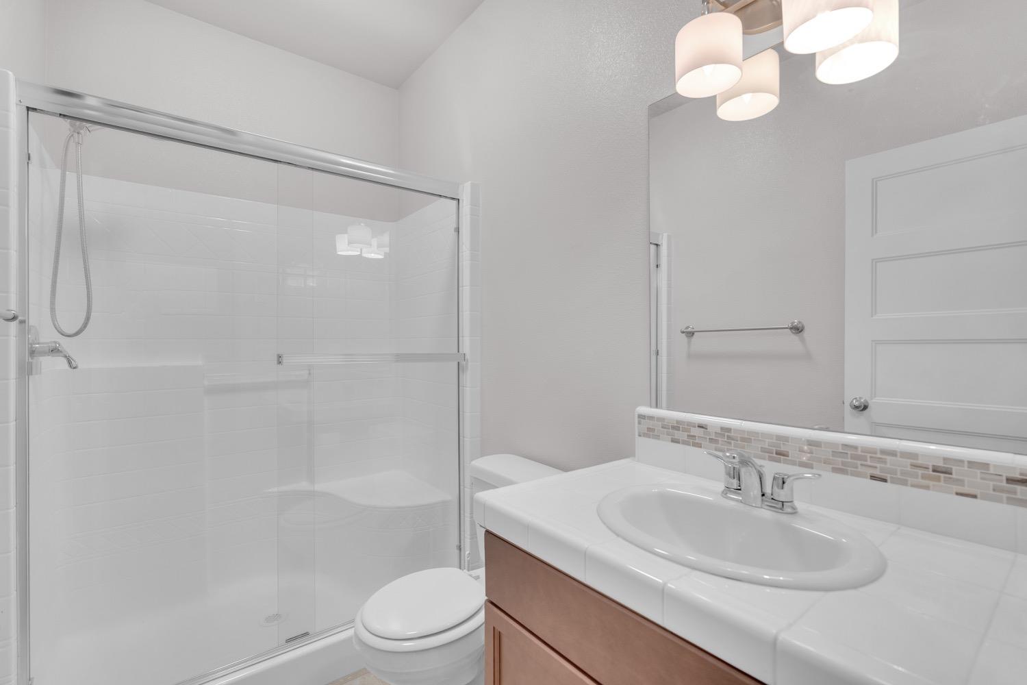 3532 Journey Way Clovis, CA 93619 - Photo 11 of 24 a bathroom with a sink a toilet and shower