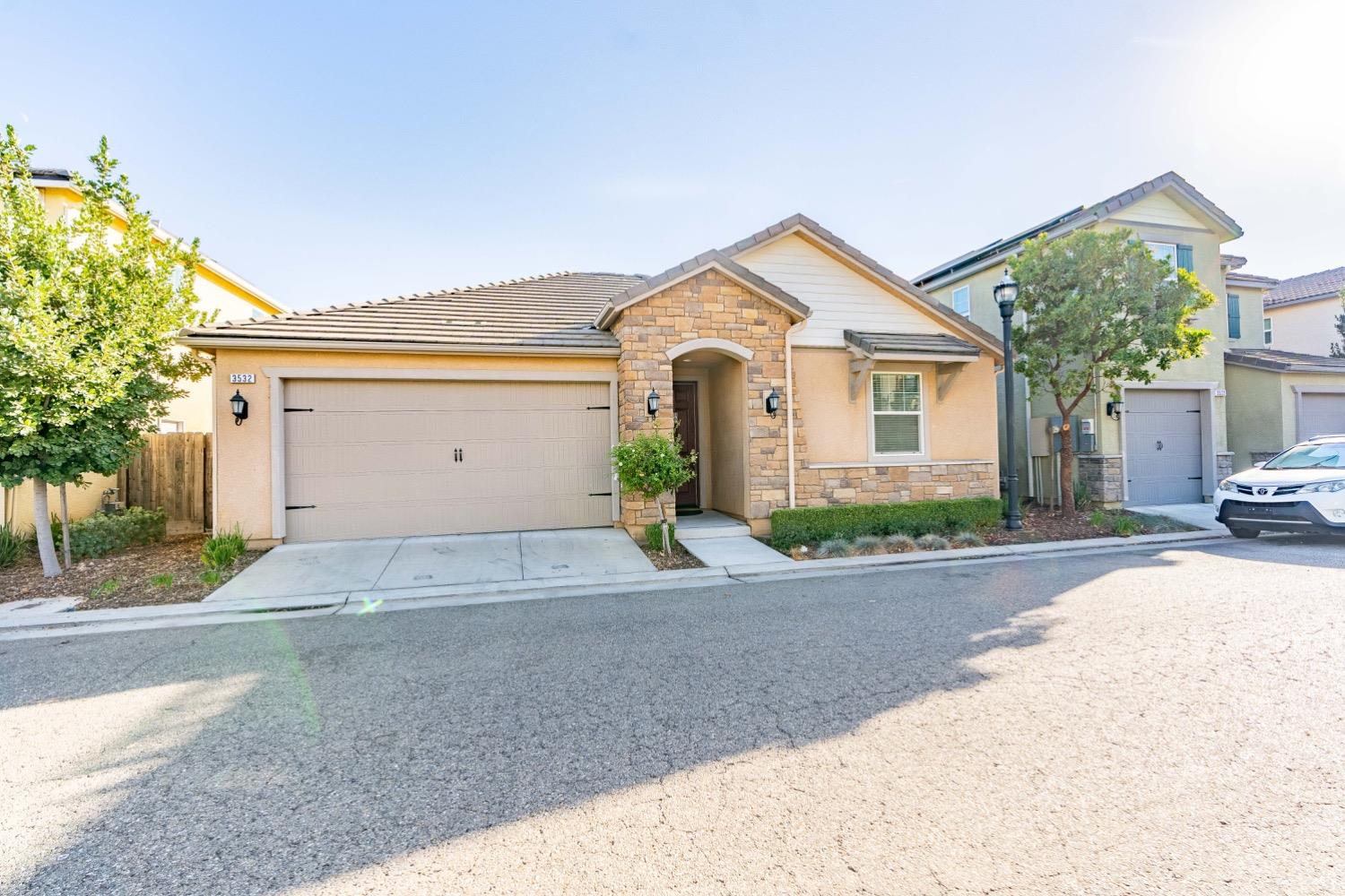 3532 Journey Way Clovis, CA 93619 - Photo 2 of 24 a front view of a house with a yard and garage