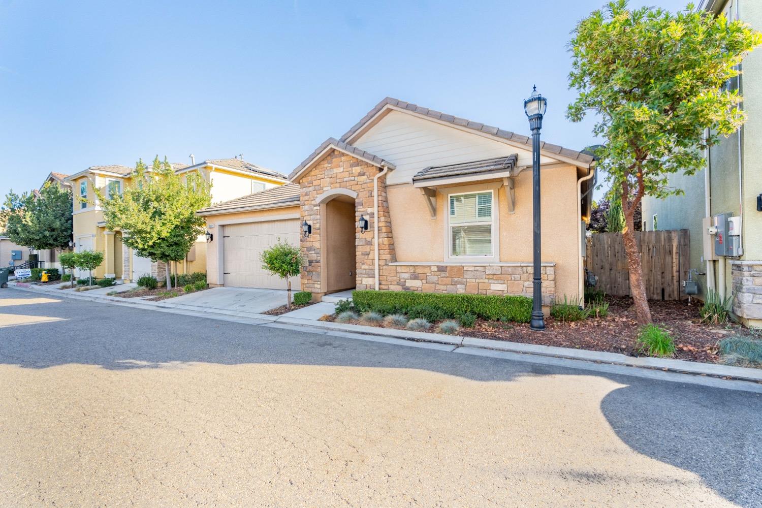 3532 Journey Way Clovis, CA 93619 - Photo 3 of 24 a front view of a house with a yard and potted plants