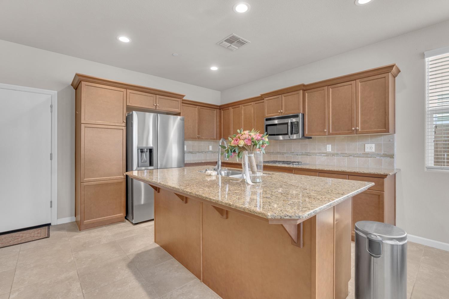 3532 Journey Way Clovis, CA 93619 - Photo 5 of 24 a kitchen with stainless steel appliances granite countertop a sink a refrigerator and a granite counter tops