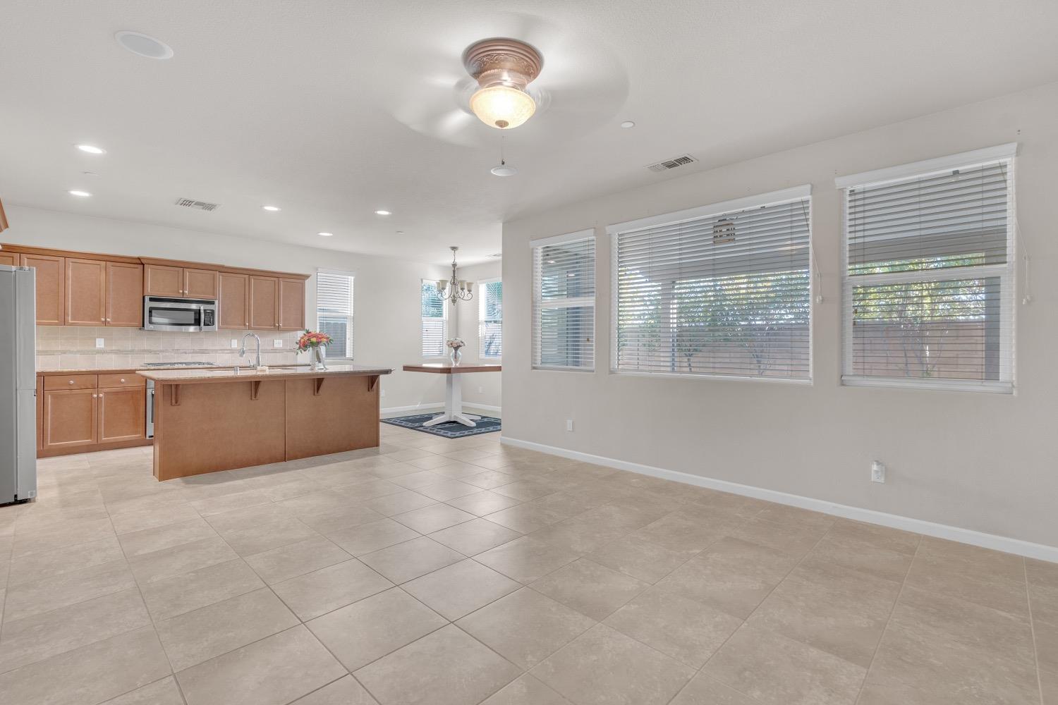 3532 Journey Way Clovis, CA 93619 - Photo 6 of 24 a large white kitchen with a large window cabinets and stainless steel appliances