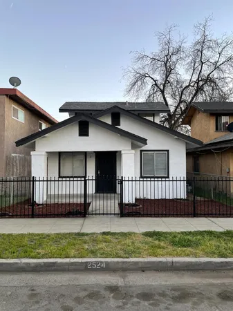 a front view of a house with a garden and deck