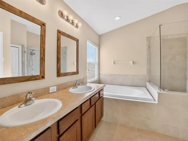 a bathroom with a tub a sink and mirror