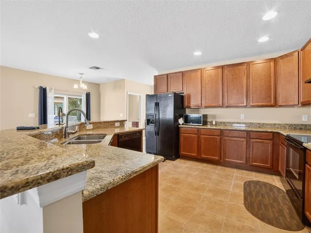 a kitchen with granite countertop a sink counter top space appliances and cabinets