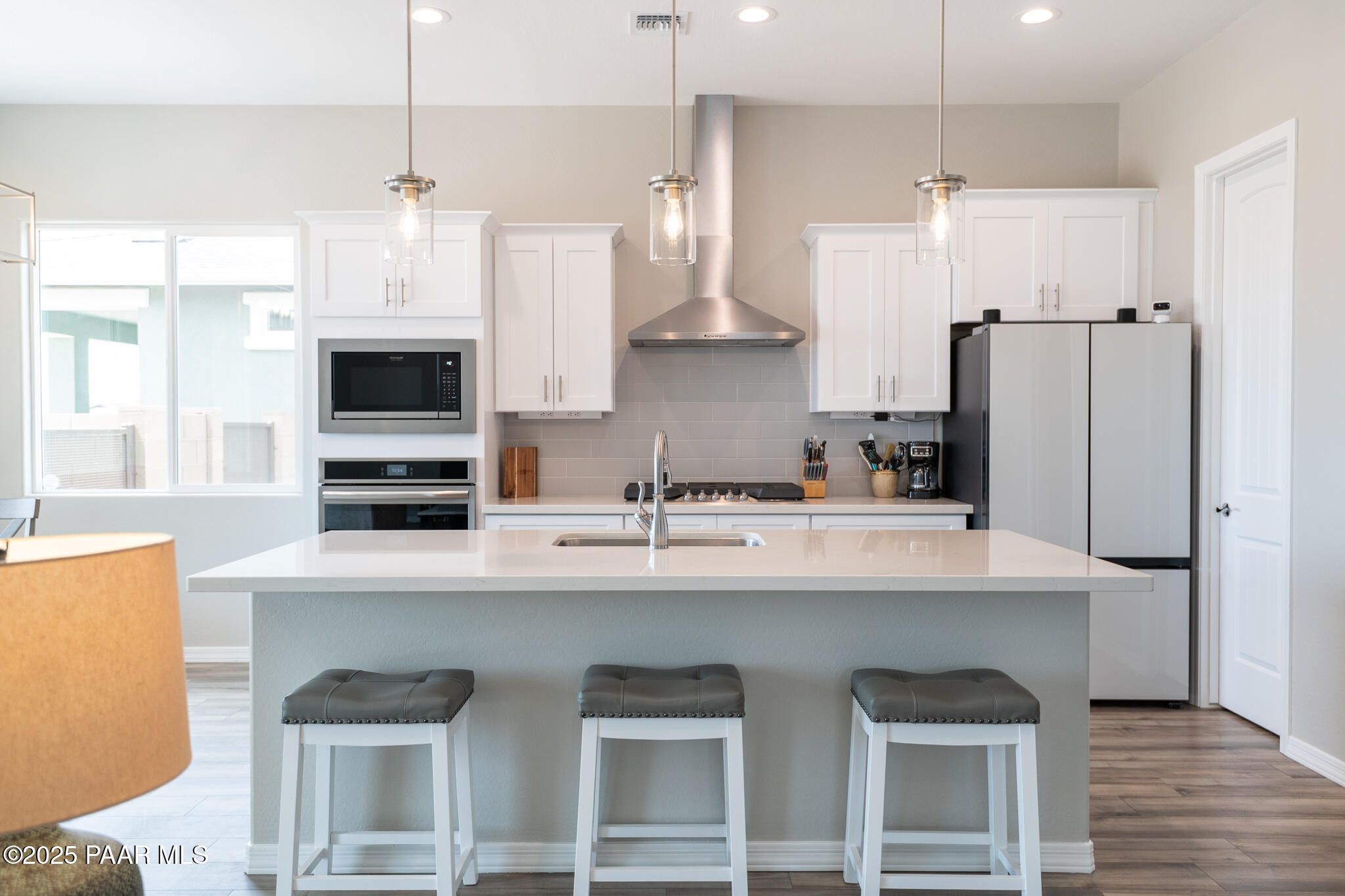 7091 Turquoise Street Prescott, AZ 86305 - Photo 4 of 27 a kitchen with stainless steel appliances granite countertop a sink a stove a refrigerator and island with wooden floor