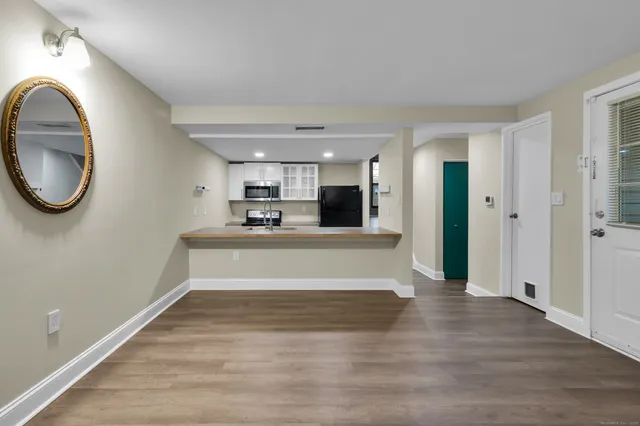 a view of a living room a kitchen and a wooden floor