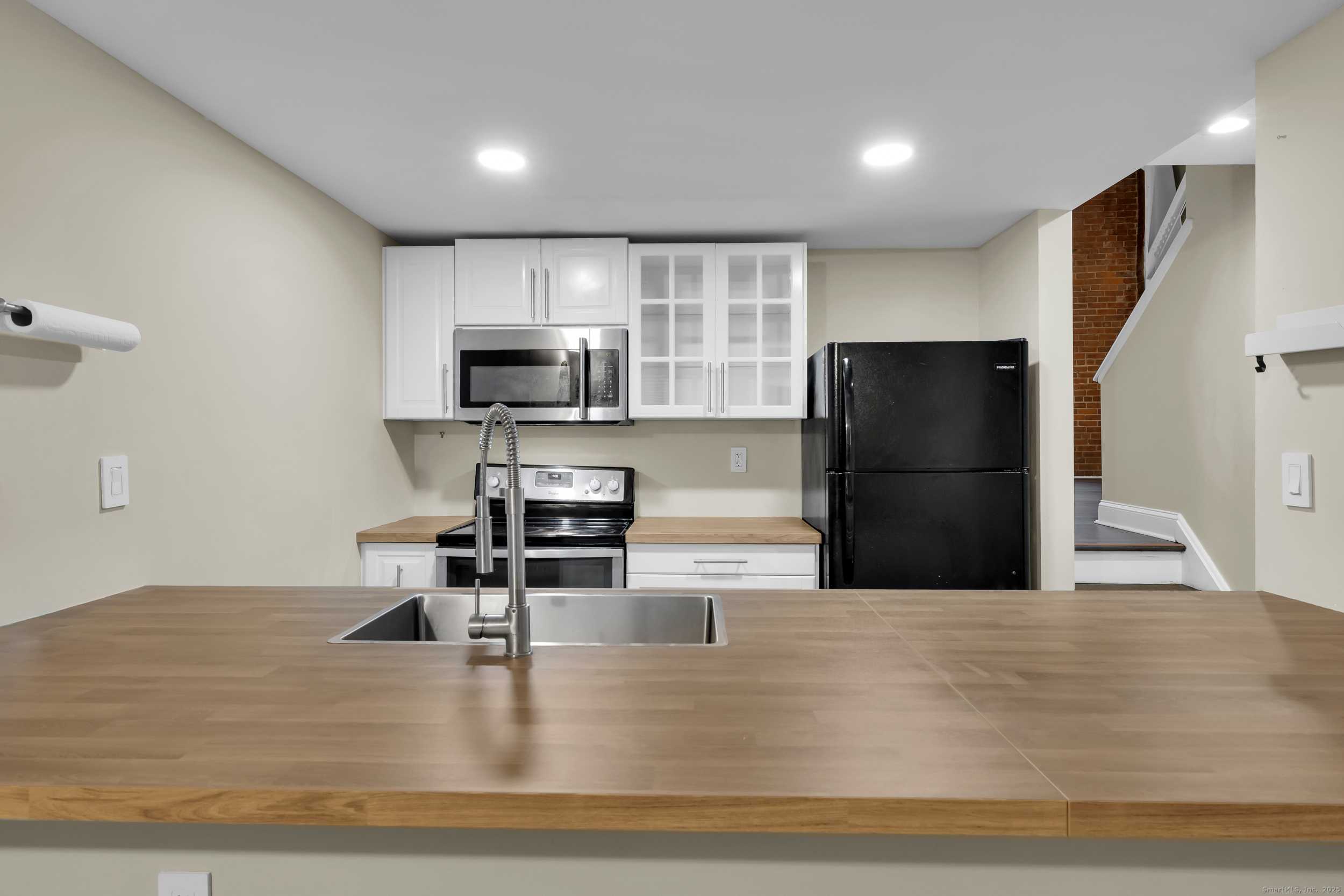 1 Front Street, Unit 113 New Haven, CT 06513 - Photo 12 of 22 a kitchen with granite countertop a refrigerator and a stove top oven