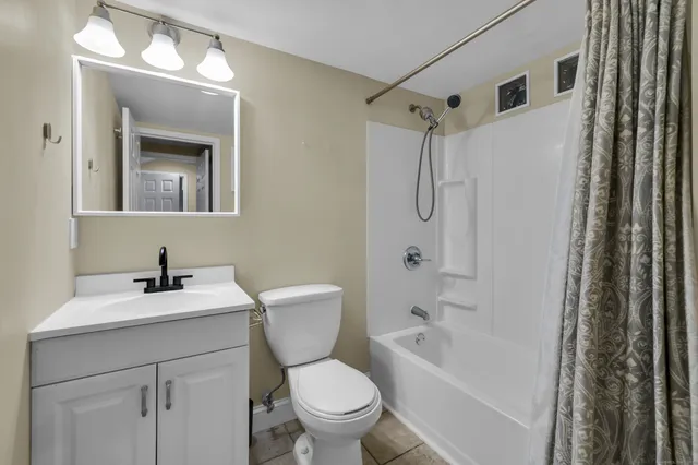 a bathroom with a sink toilet vanity and shower