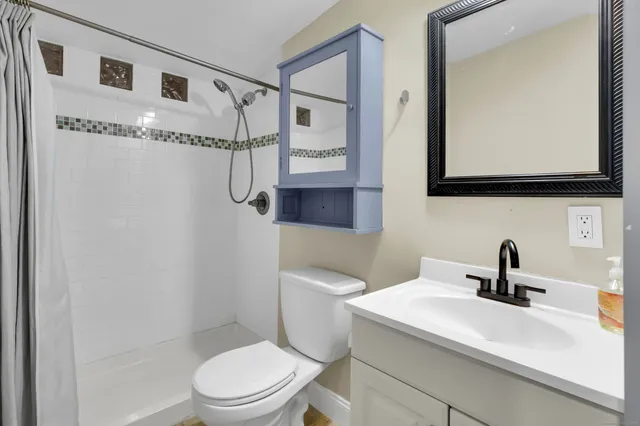 a bathroom with a sink a toilet and mirror