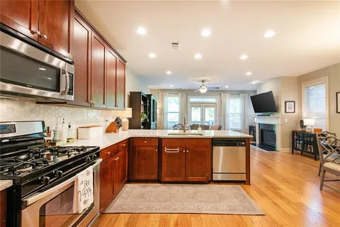 a kitchen with stainless steel appliances granite countertop a refrigerator a sink a stove a microwave and island