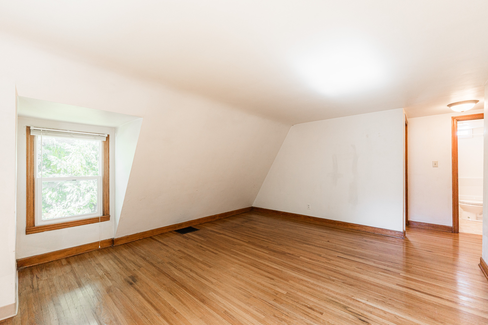 512 North 6th Street, Unit 2 DeKalb, IL 60115 - Photo 11 of 16 an empty room with wooden floor and windows
