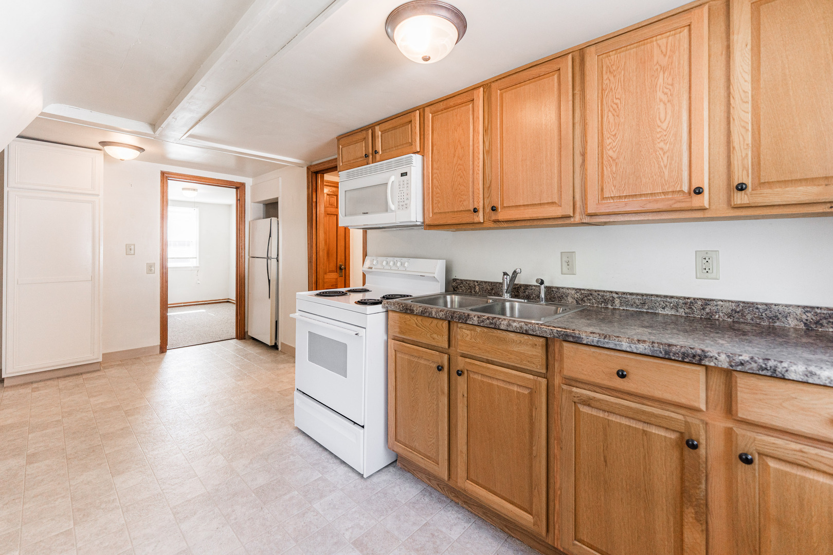 512 North 6th Street, Unit 2 DeKalb, IL 60115 - Photo 8 of 16 a kitchen with granite countertop white cabinets and white appliances