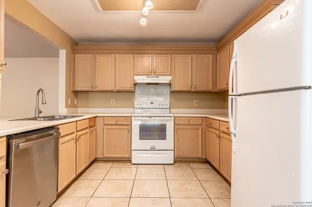 a kitchen with a stove sink and refrigerator