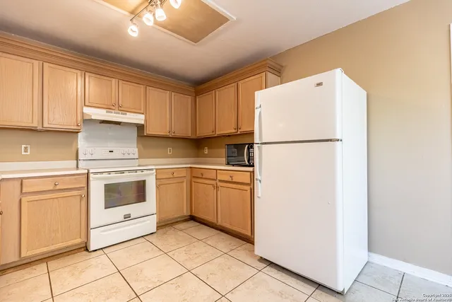 a white refrigerator freezer sitting inside of a kitchen