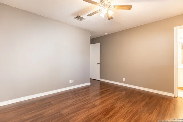 a view of an empty room with wooden floor