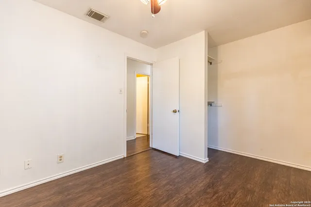 a view of an empty room with wooden floor