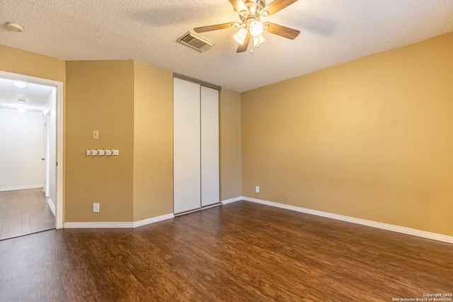 a view of an empty room with wooden floor