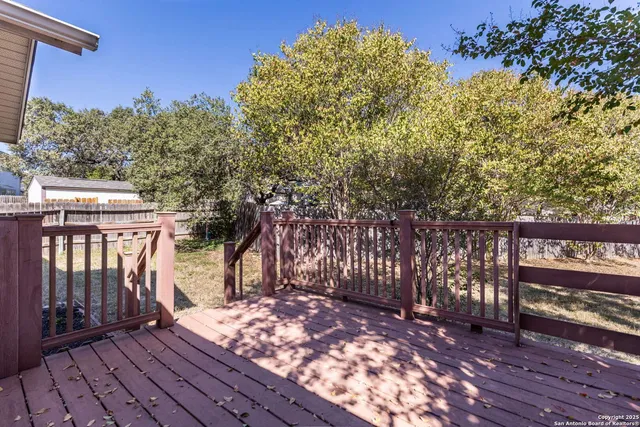 a view of a backyard with wooden fence