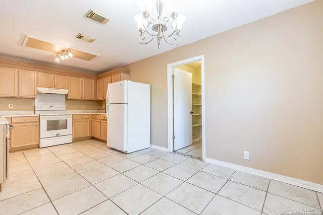 a kitchen with a refrigerator a stove top oven and cabinets
