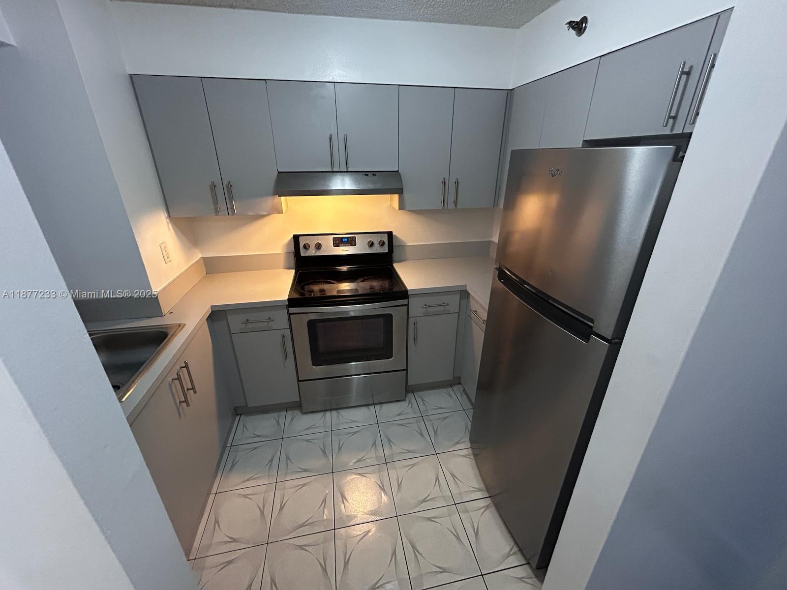 501 Southwest 1st Street, Unit 411 Miami, FL 33130 - Photo 5 of 18 a kitchen with stainless steel appliances a refrigerator and a stove