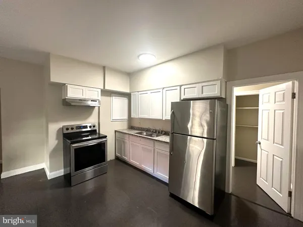 a kitchen with a refrigerator and a stove top oven