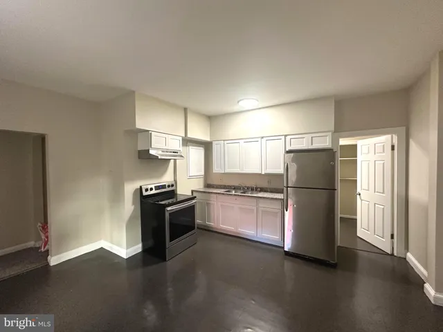 a view of a kitchen with a stove wooden floor and a window