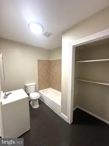 a bathroom with a toilet a sink and mirror