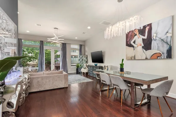 a living room with furniture kitchen view and a chandelier