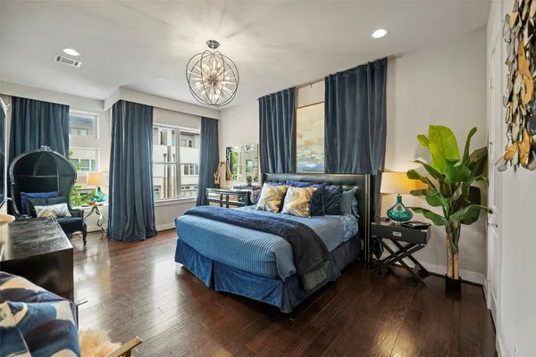 a bathroom with a sink a large mirror and a bathtub with a potted plant