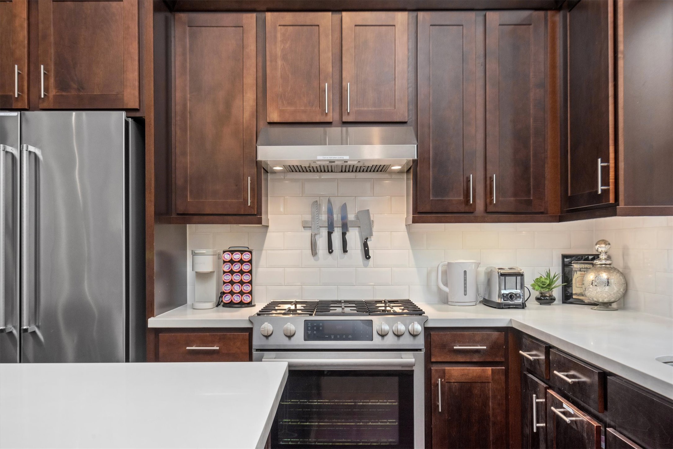 4413 Eli Street Houston, TX 77007 - Photo 8 of 47 a kitchen with stainless steel appliances wooden cabinets and a stove top oven