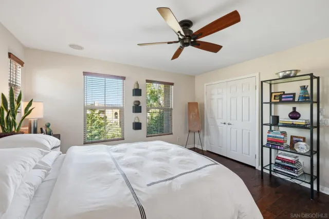 a bedroom with a bed a dresser and a large window