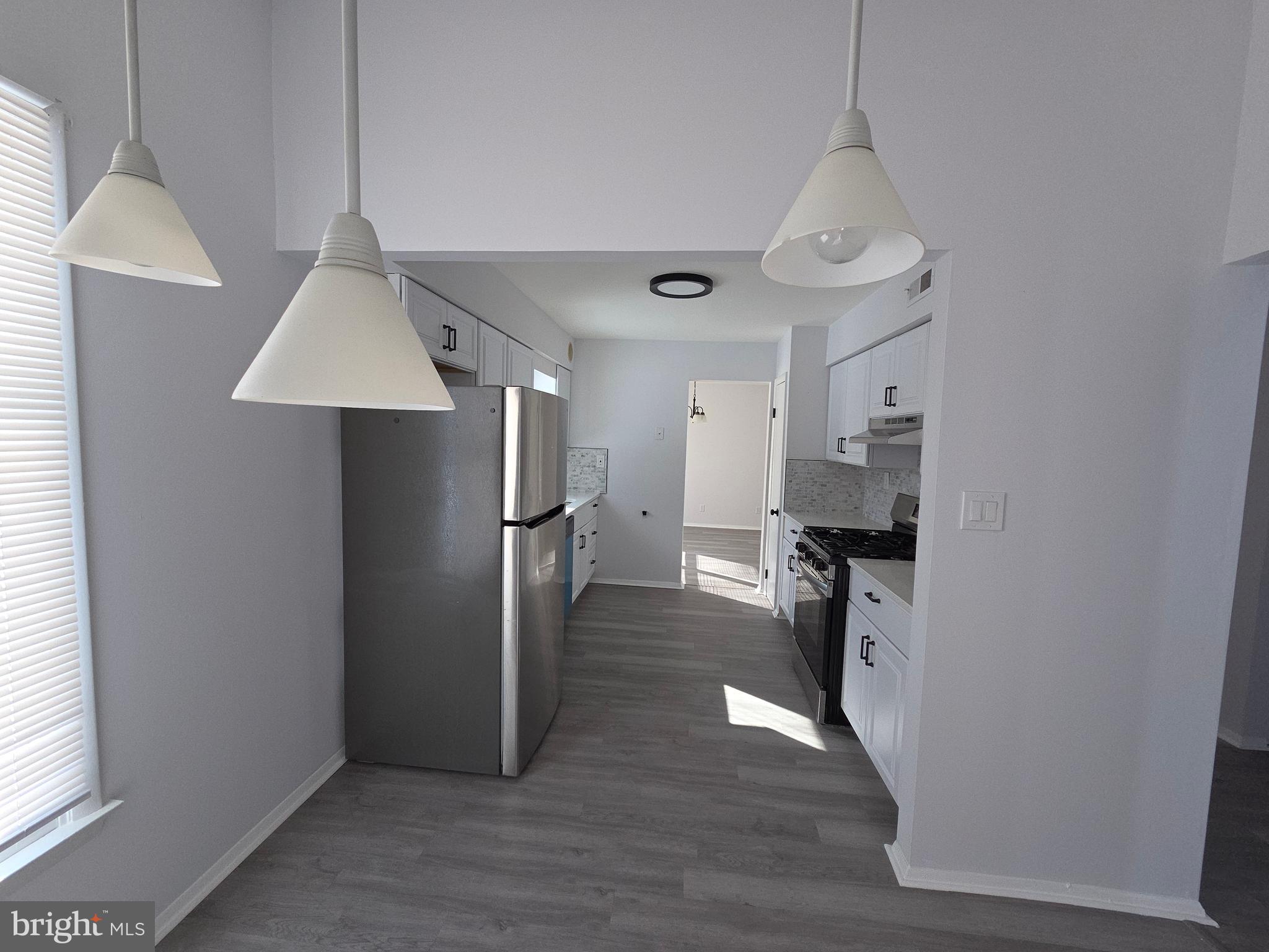 70 Suburban Boulevard Delran, NJ 08075 - Photo 4 of 40 a view of a kitchen with a refrigerator a stove top oven and cabinets