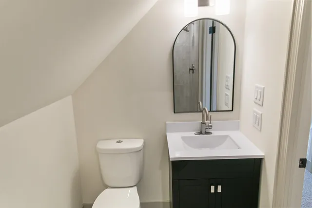 a bathroom with a toilet sink and mirror
