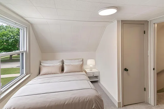 a bedroom with a bed and a large window