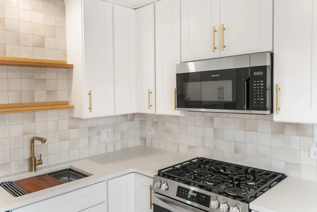 a kitchen with microwave stove and cabinets