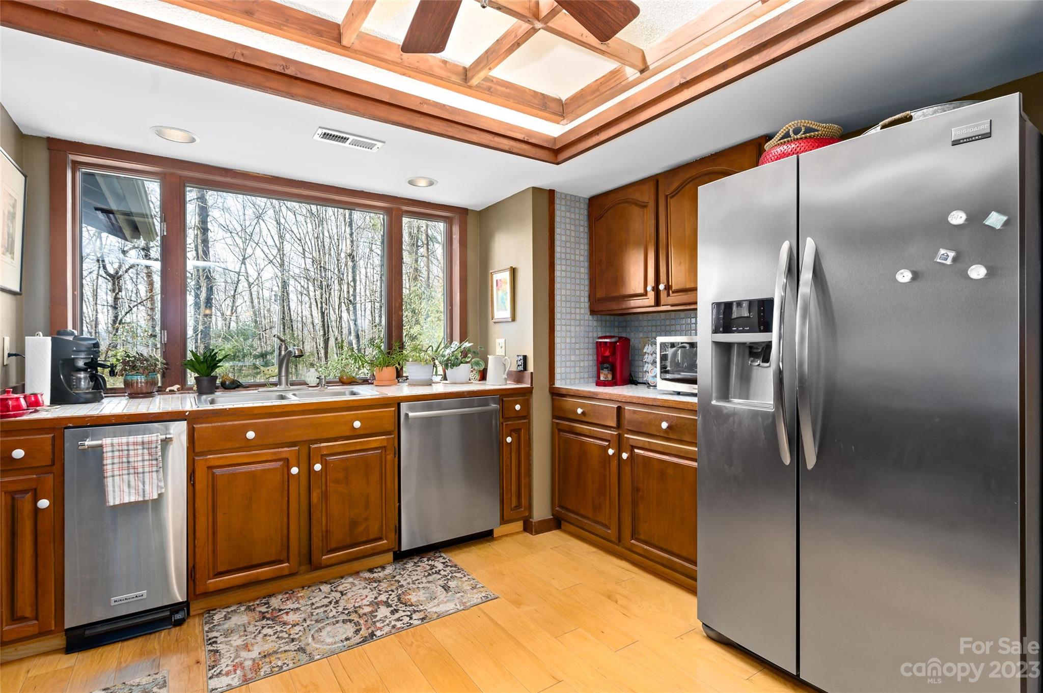 139 Panther Gap Road Brevard, NC 28712 - Photo 19 of 42 a kitchen with stainless steel appliances granite countertop a refrigerator and wooden cabinets