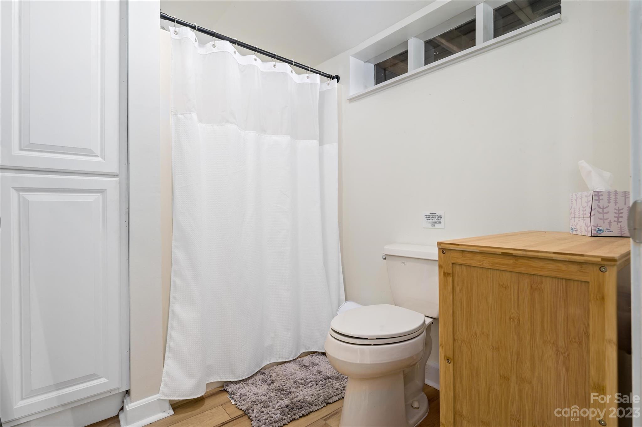 139 Panther Gap Road Brevard, NC 28712 - Photo 36 of 42 a white toilet sitting next to a shower curtain