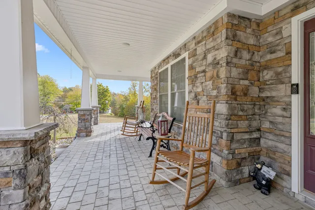 a living room with furniture a flat screen tv and kitchen view