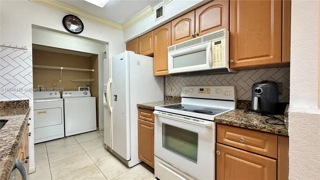 a kitchen with stainless steel appliances granite countertop a stove a refrigerator and a cabinets