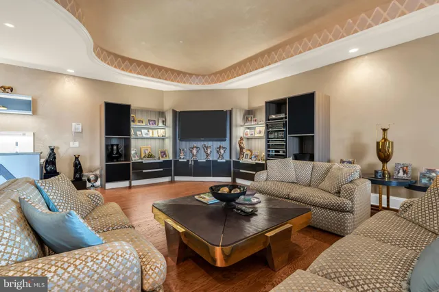 a living room with furniture a flat screen tv and kitchen view
