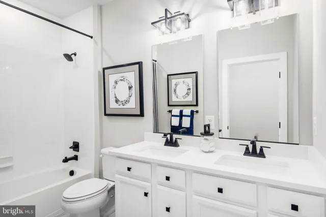 a bathroom with a bathtub shower sink vanity and toilet