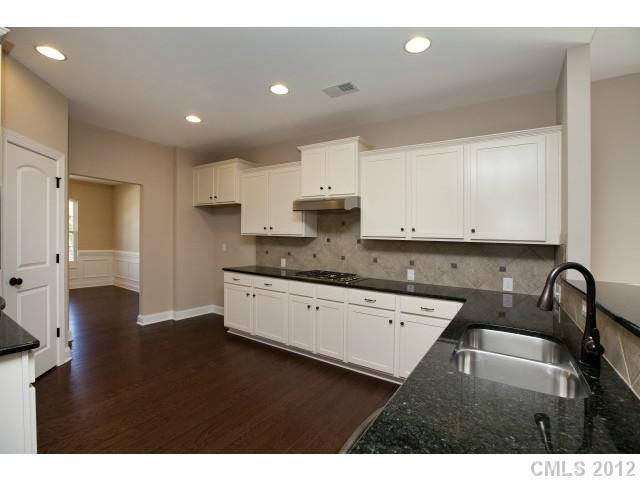86593 Arrington Road, Unit 102 Lancaster, SC 29720 - Photo 8 of 15 a kitchen with granite countertop a sink cabinets and wooden floor