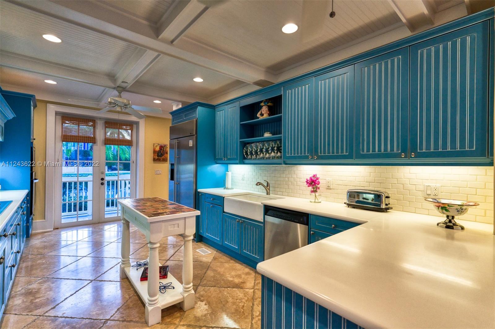 32 Sunset Key Drive Key West, FL 33040 - Photo 10 of 49 a kitchen with stainless steel appliances kitchen island granite countertop a table chairs in it and wooden floors