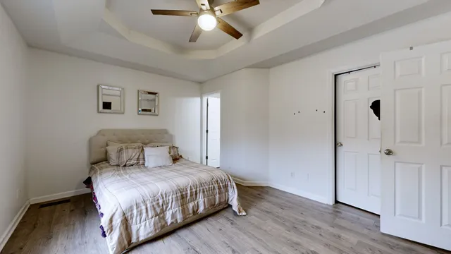 a bedroom with a large bed and a chandelier
