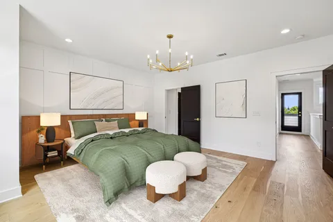 a bedroom with a large bed and a chandelier