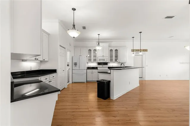 a kitchen with stainless steel appliances granite countertop a refrigerator a stove and a sink